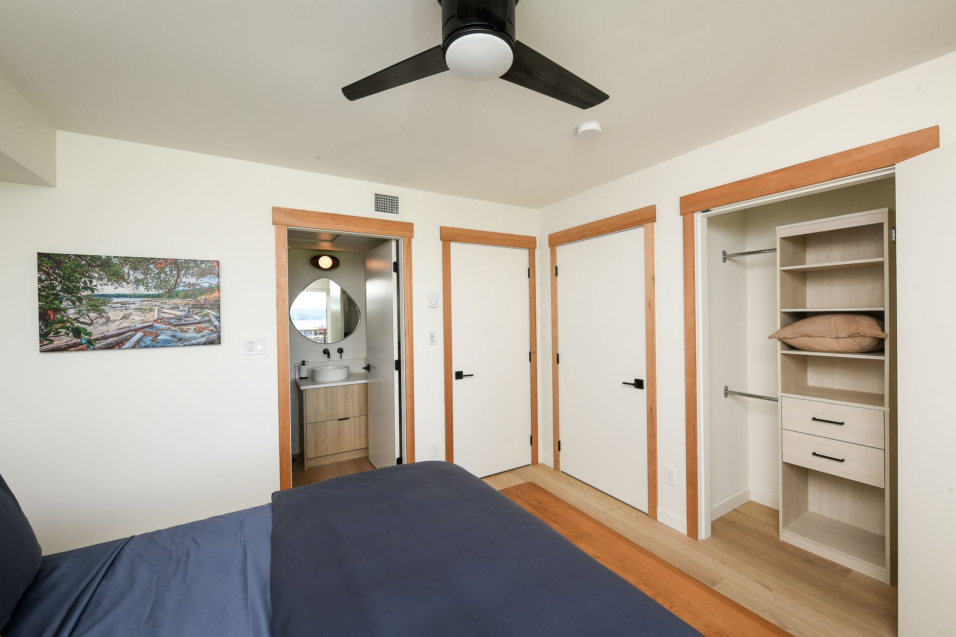 A bedroom with a ceiling fan and a closet