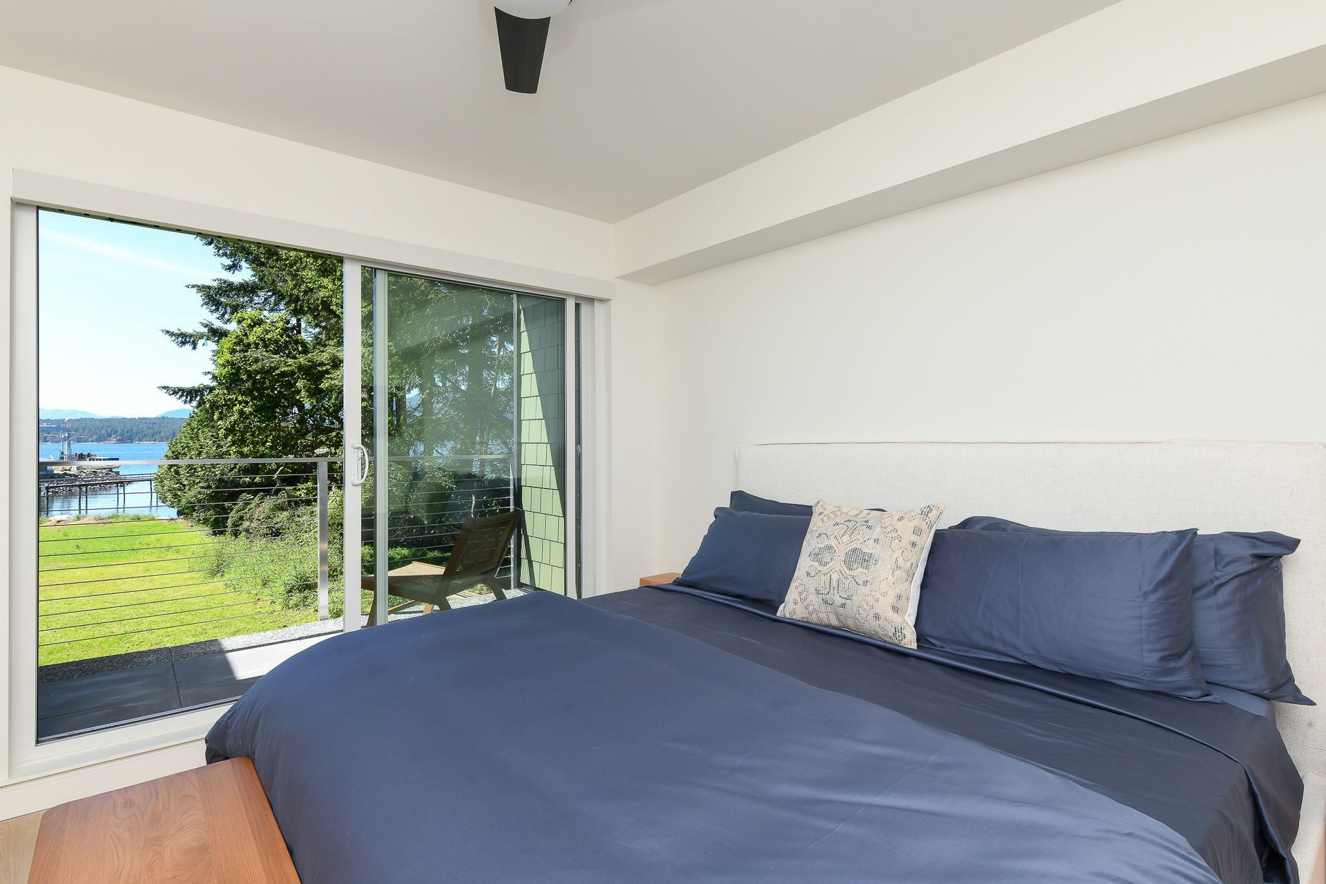 A bedroom with a large bed and a sliding glass door.