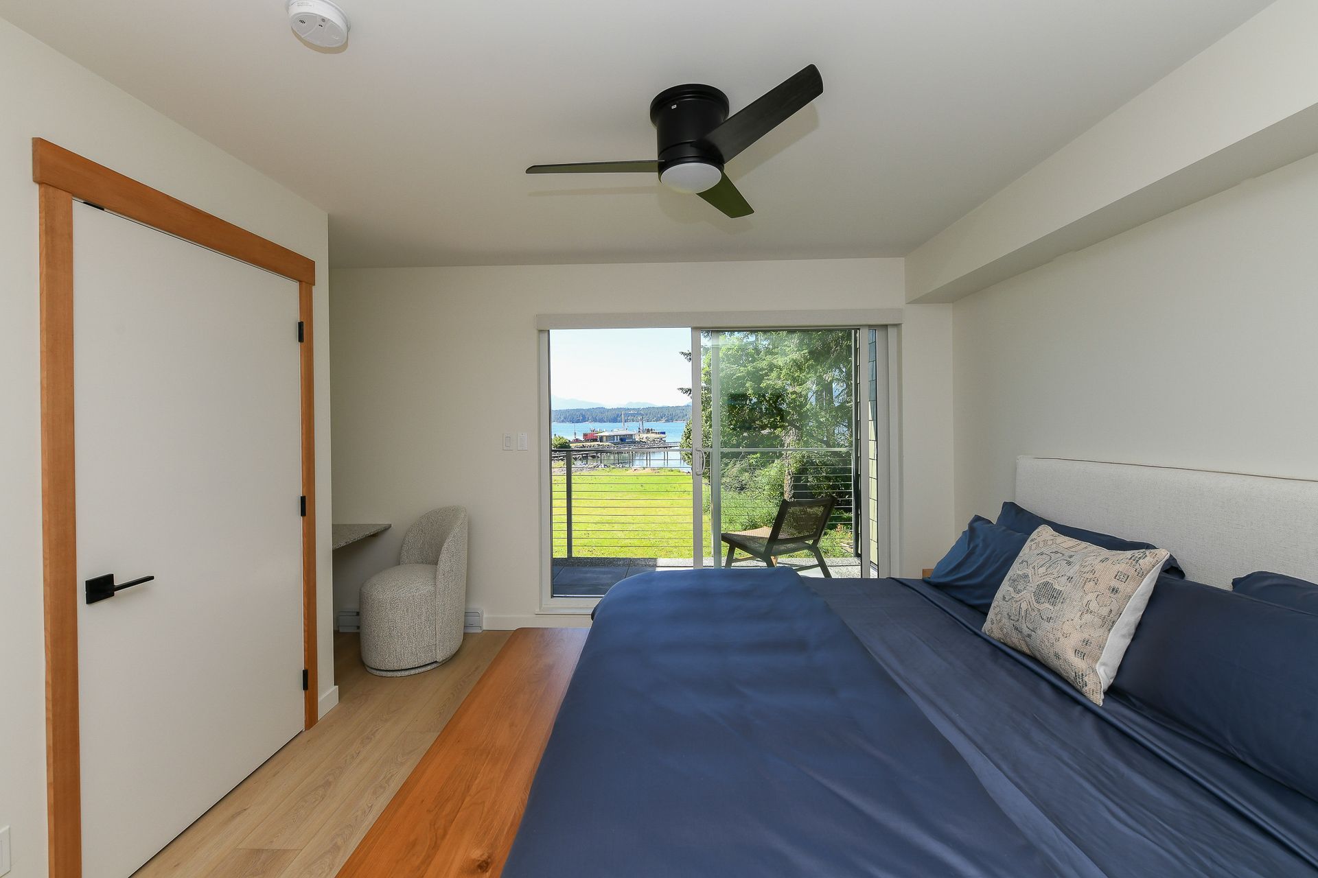 A bedroom with a large bed and a ceiling fan