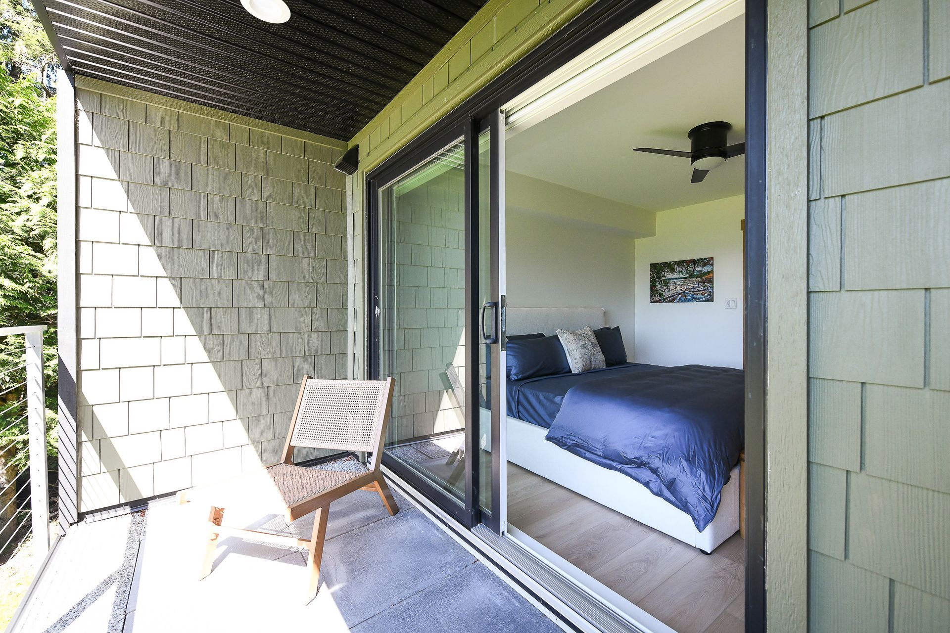 A bedroom with a sliding glass door leading to a balcony.