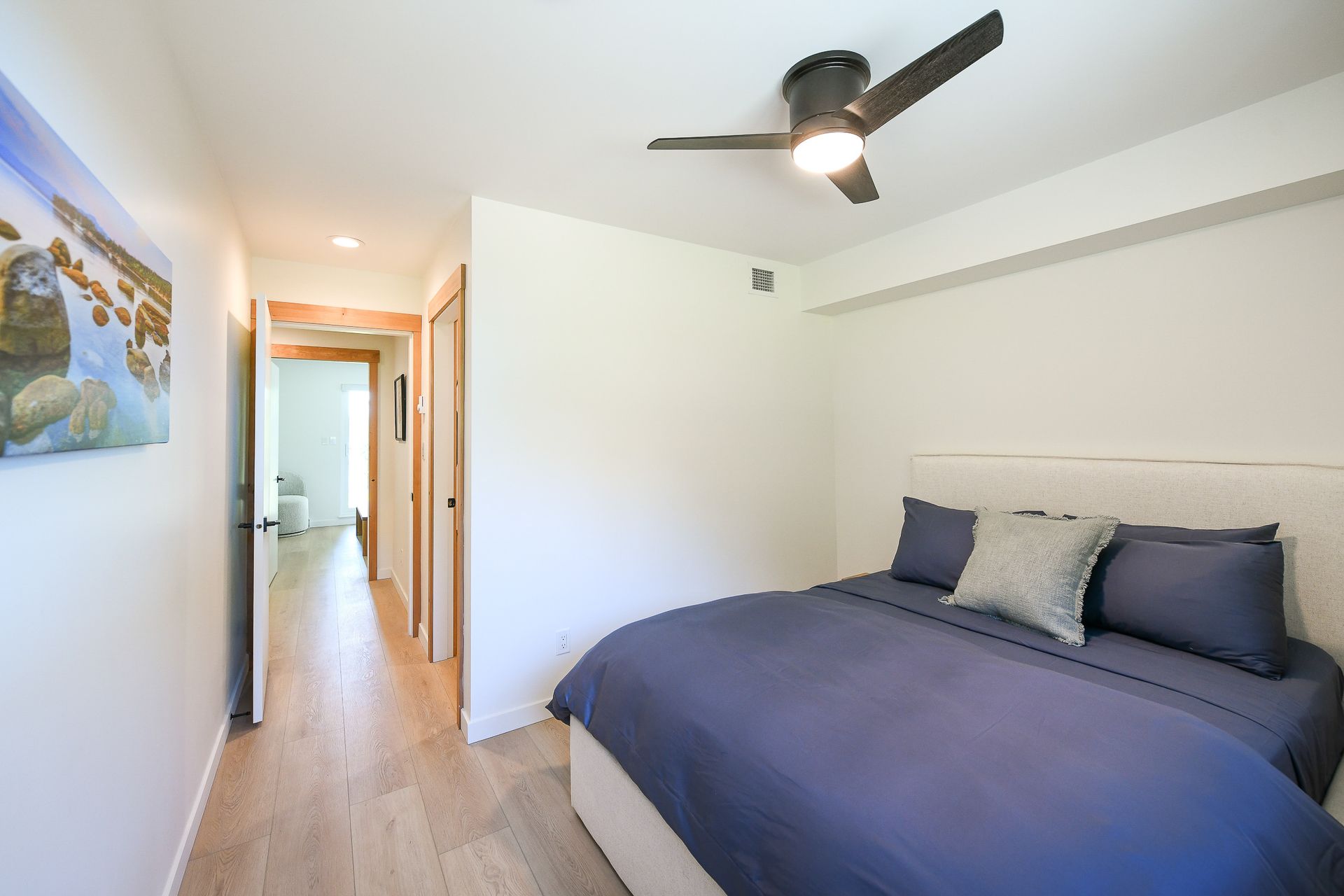 A bedroom with a bed and a ceiling fan.