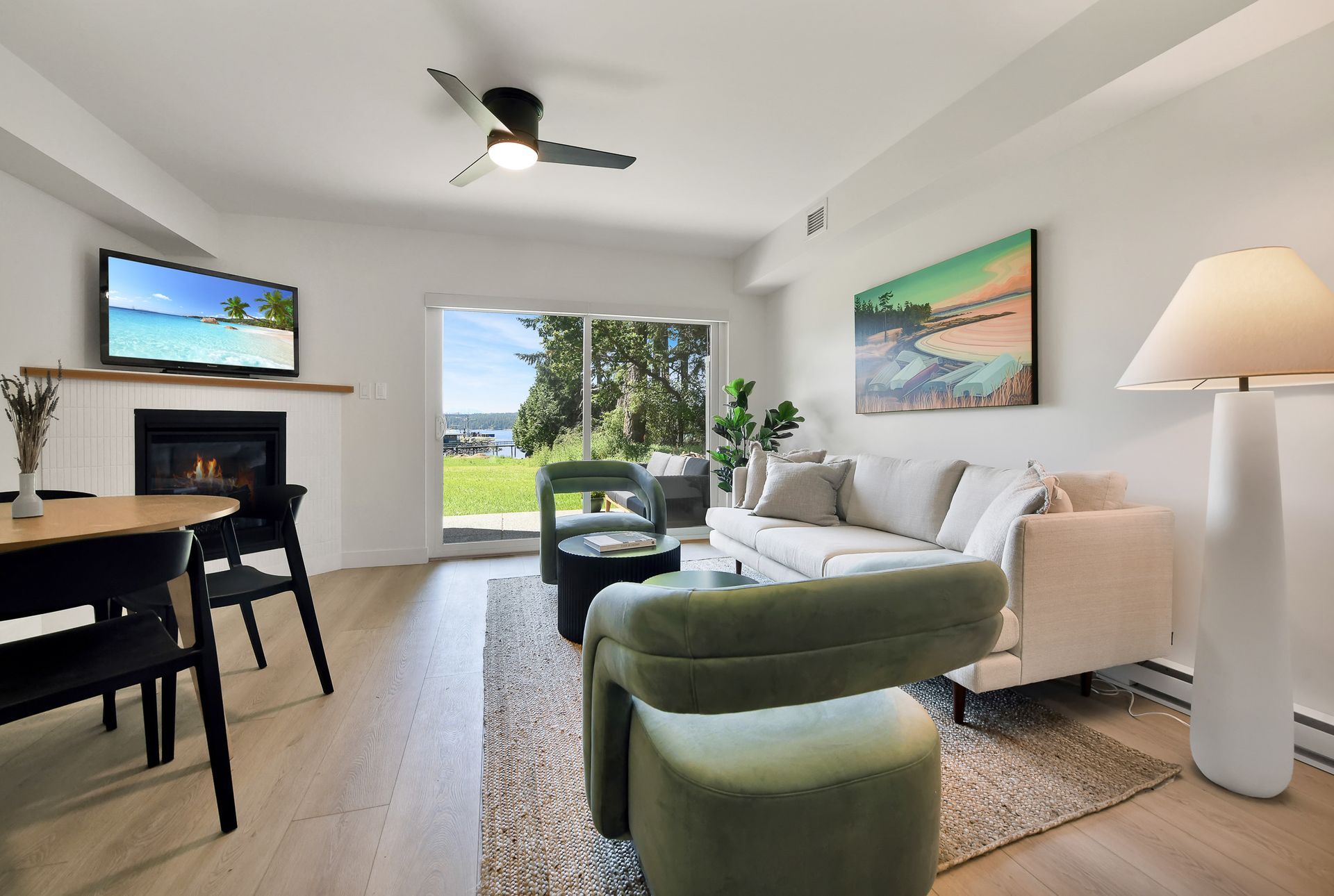 A living room with a couch , chairs , table and television