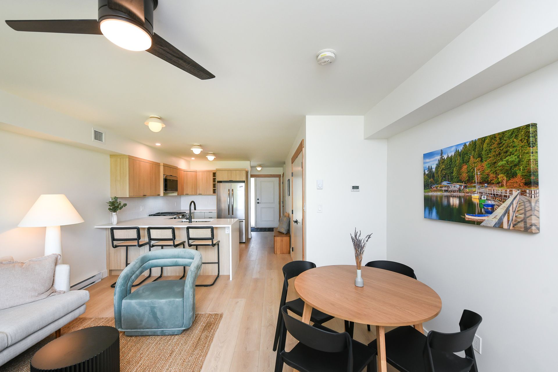 A living room with a table and chairs and a ceiling fan.