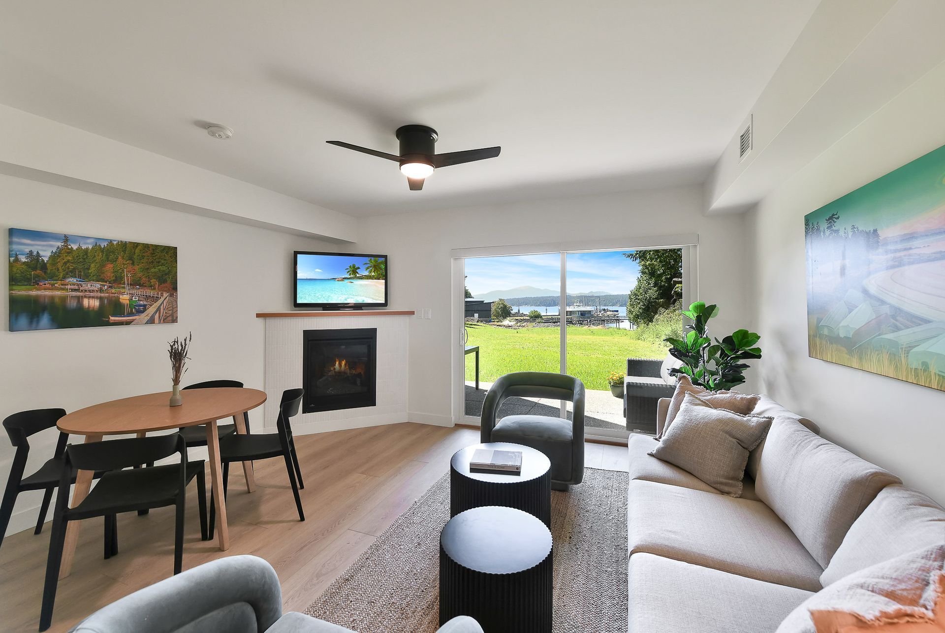 A living room with a couch , chairs , table and television.