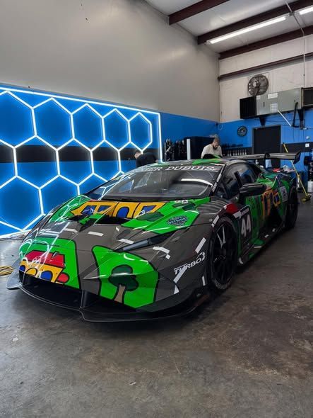 Black BMW sports car parked on a rooftop, sunny day.
