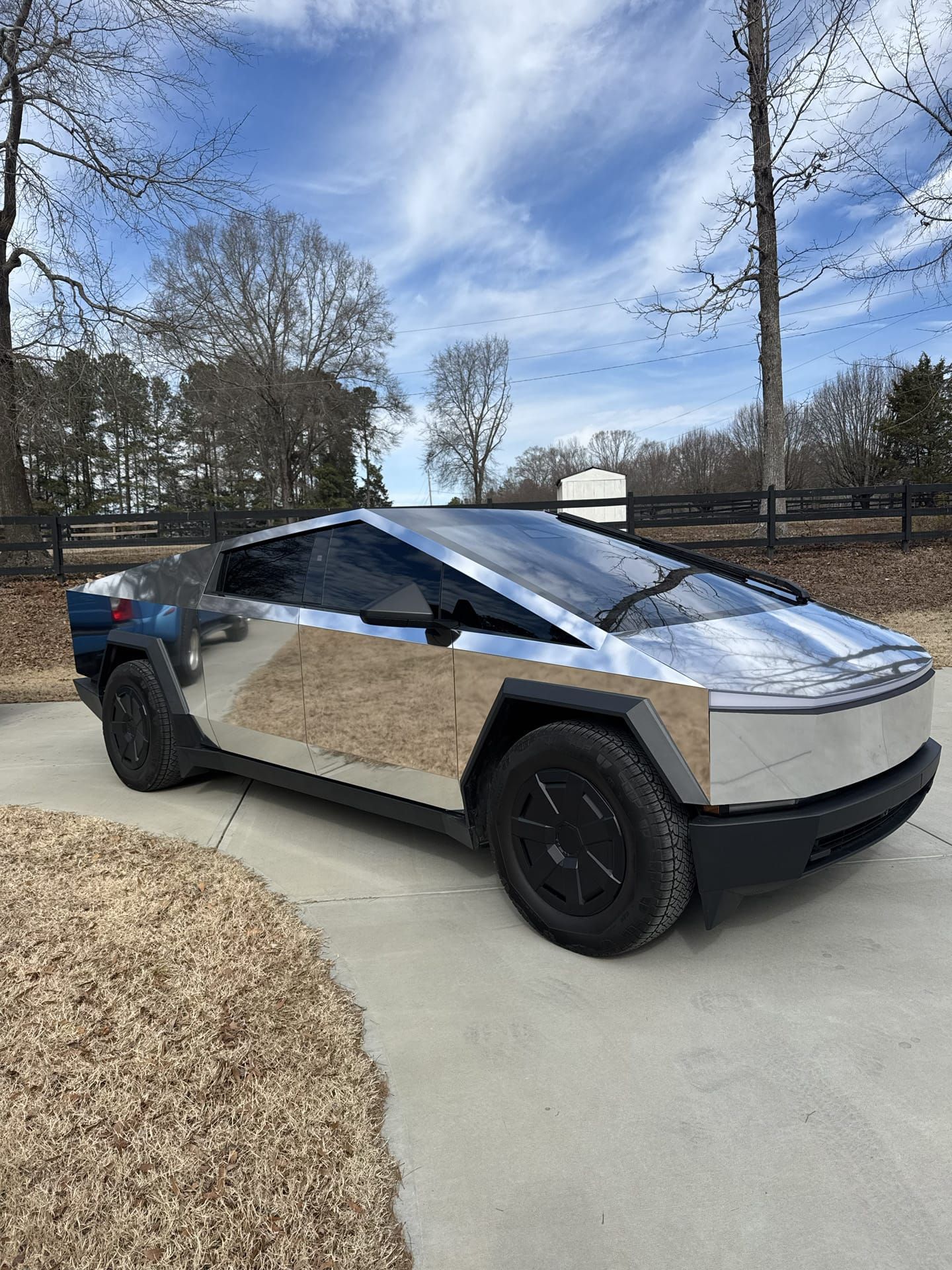 Tesla Cybertruck prototype with mismatched side panels, parked on a driveway.