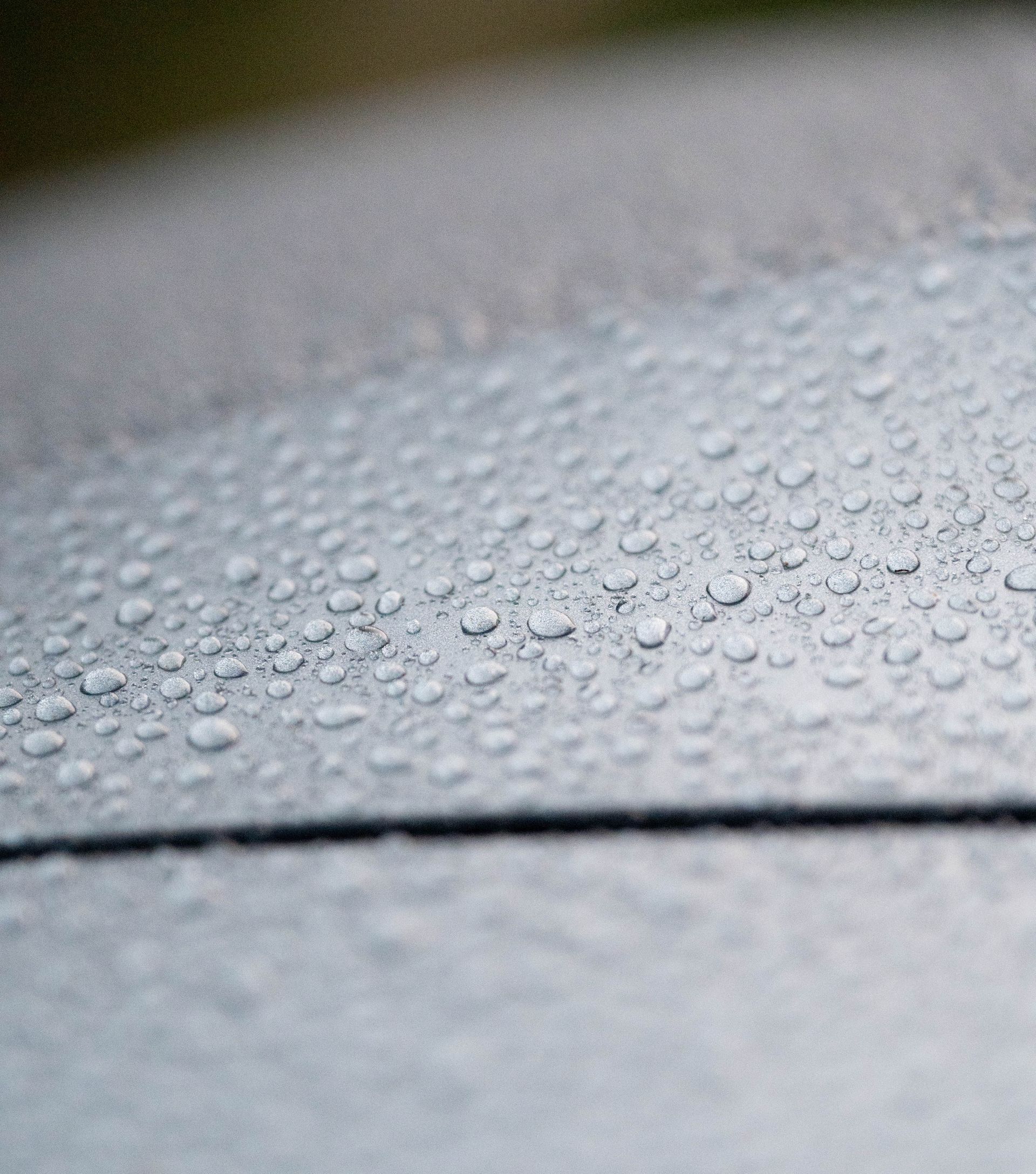 Water droplets on a dark, reflective surface.