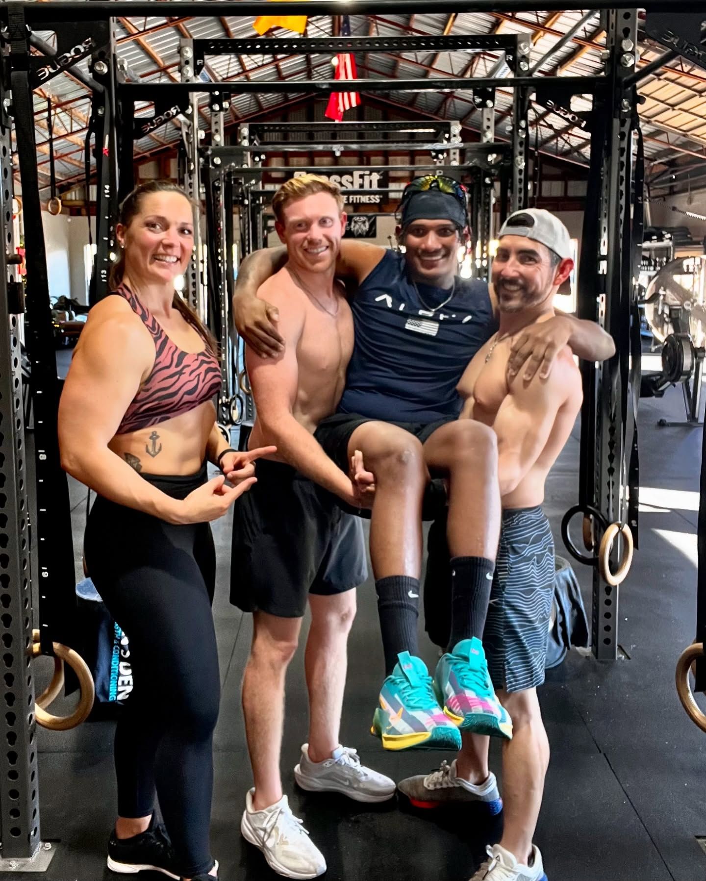 A group of people are posing for a picture in a gym.