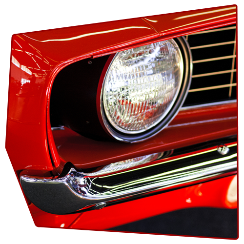 Red classic car headlight, chrome trim, black grill.