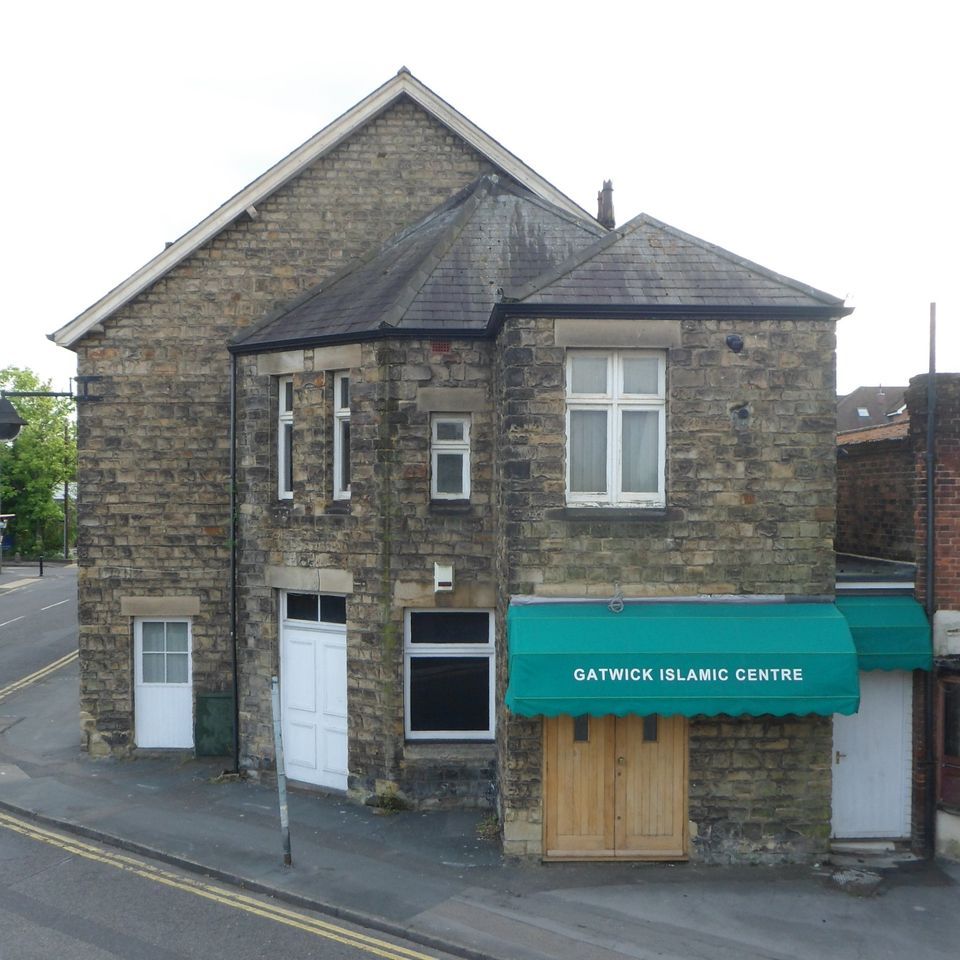 A brick building with a green awning that says gatwick islamic centre