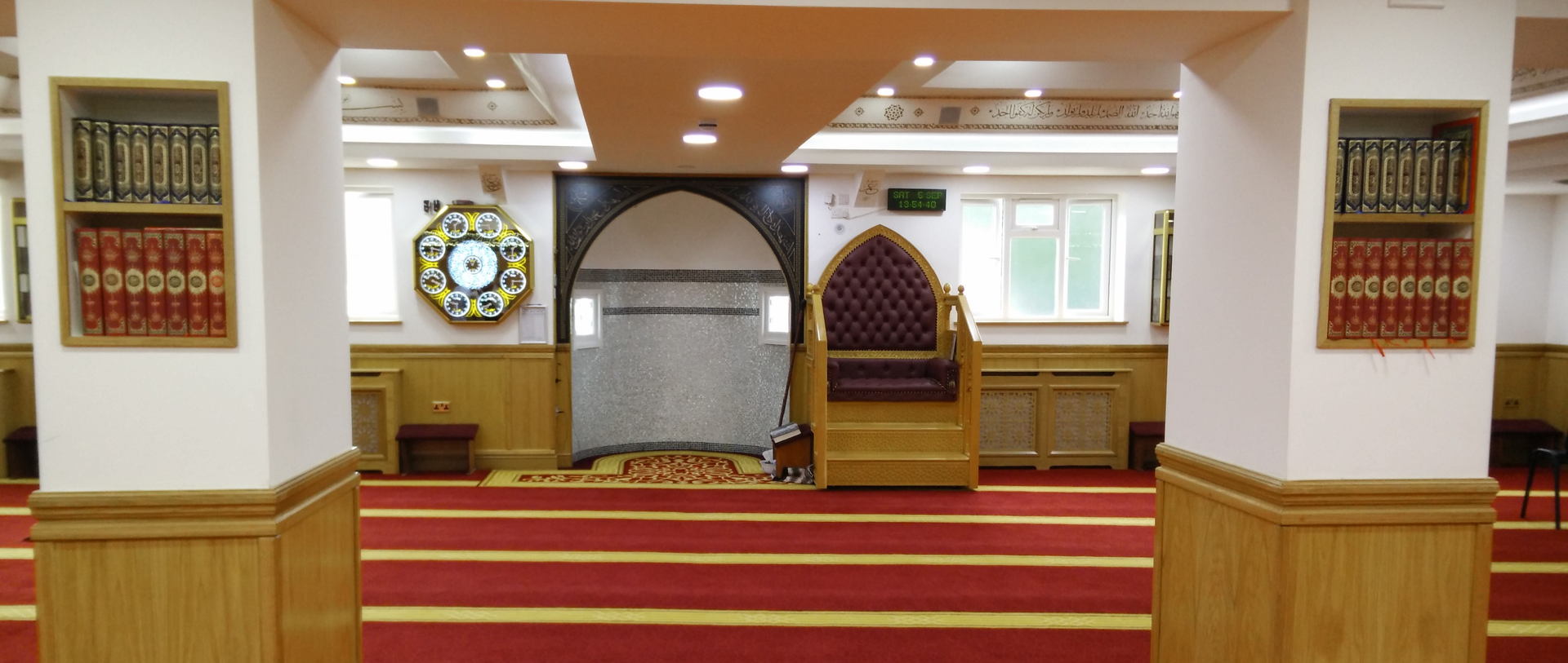 The inside of a mosque with a clock on the wall