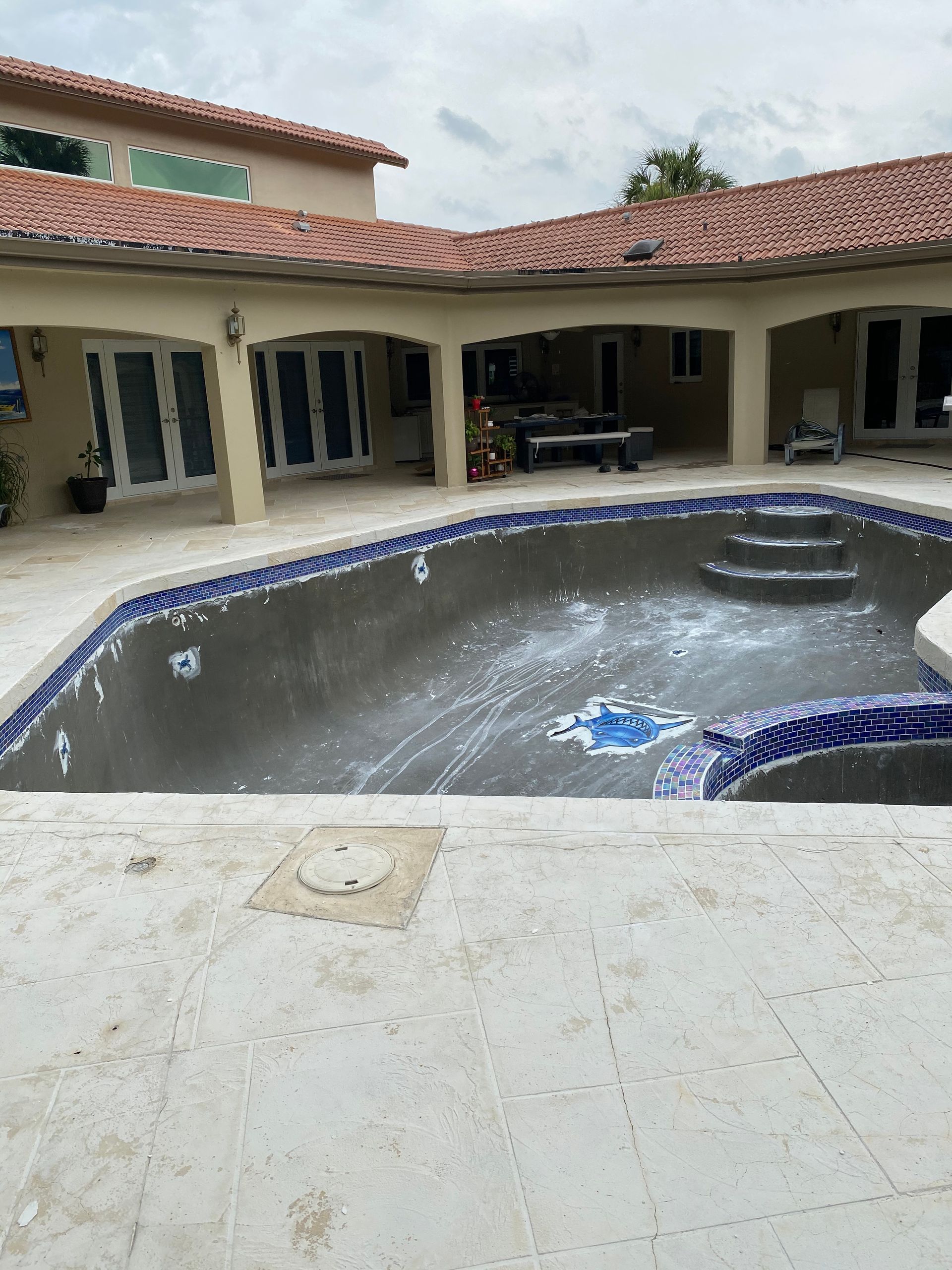A large swimming pool in front of a large house.