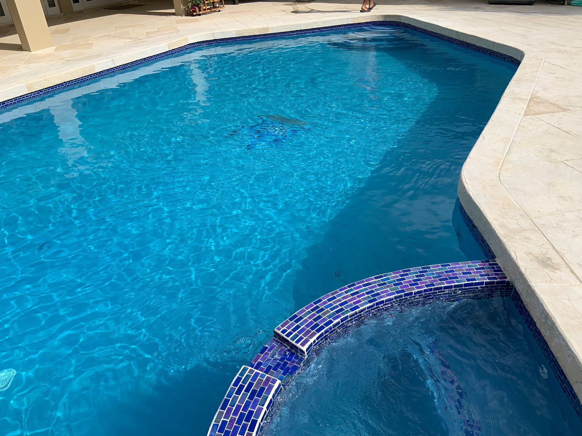 A large swimming pool with a waterfall in the middle of it.