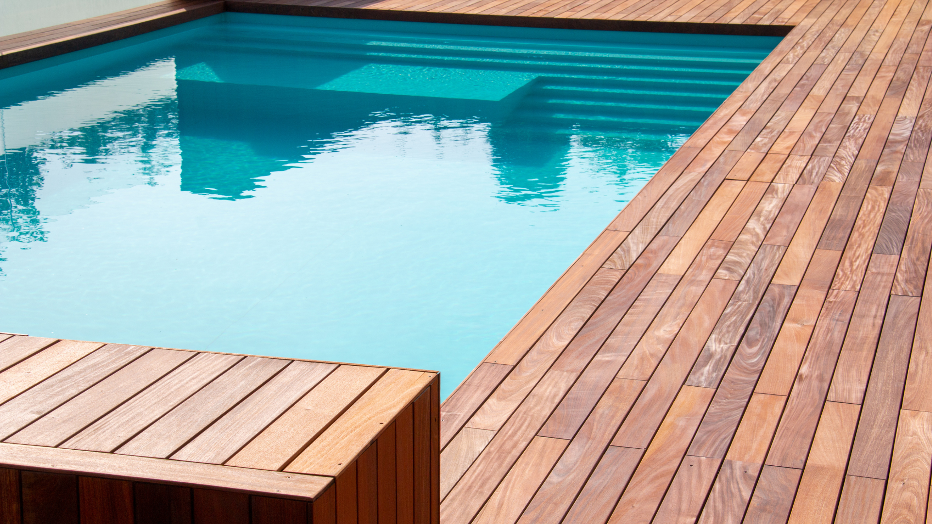 A swimming pool with a wooden deck around it