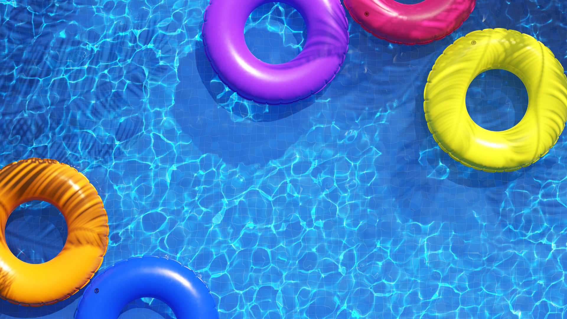 A group of colorful life rings are floating in a swimming pool.