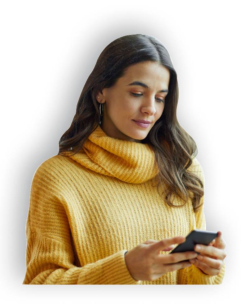 A woman in a yellow sweater is looking at her cell phone.