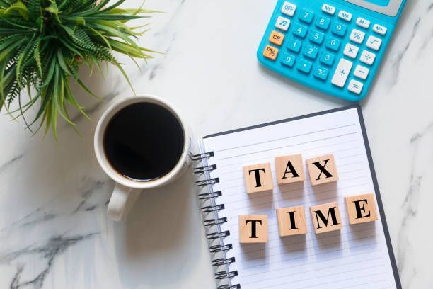 A blue calculator, coffee mug, and wooden blocks spelling
