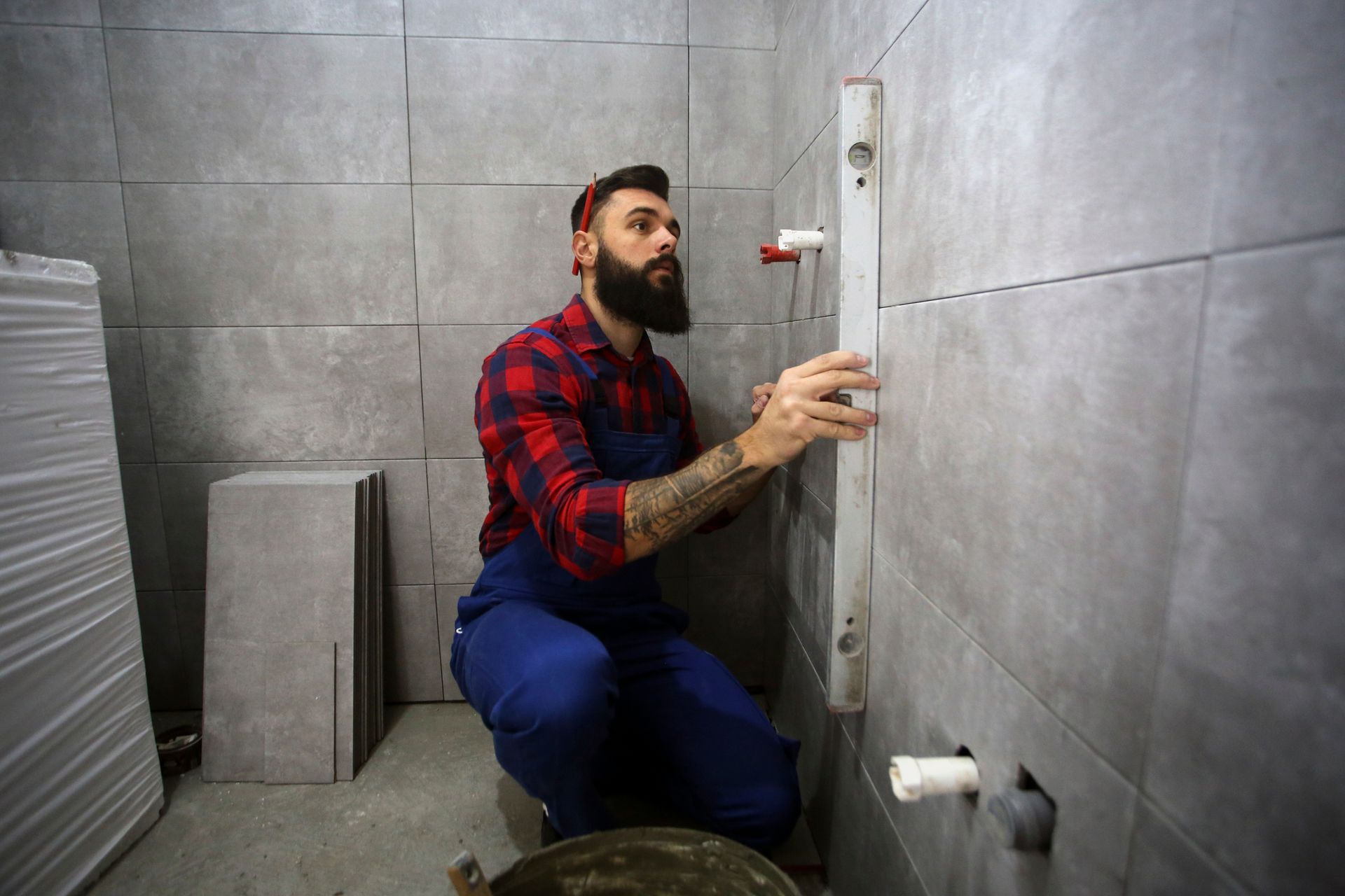 Bathroom remodel contractor on a construction site of a new bathroom, measuring with a level.