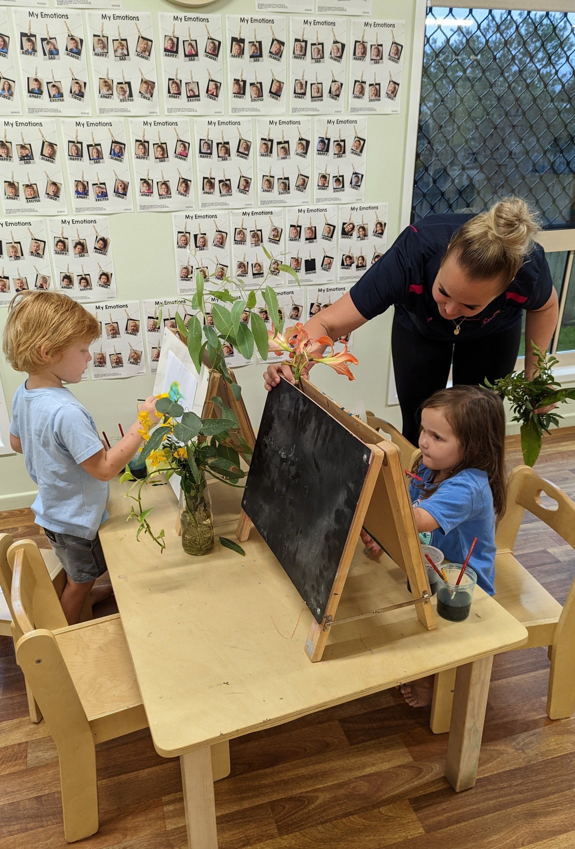Teachers Holding Plants While Kids Painting — Emu Park, QLD — Coastal Kids