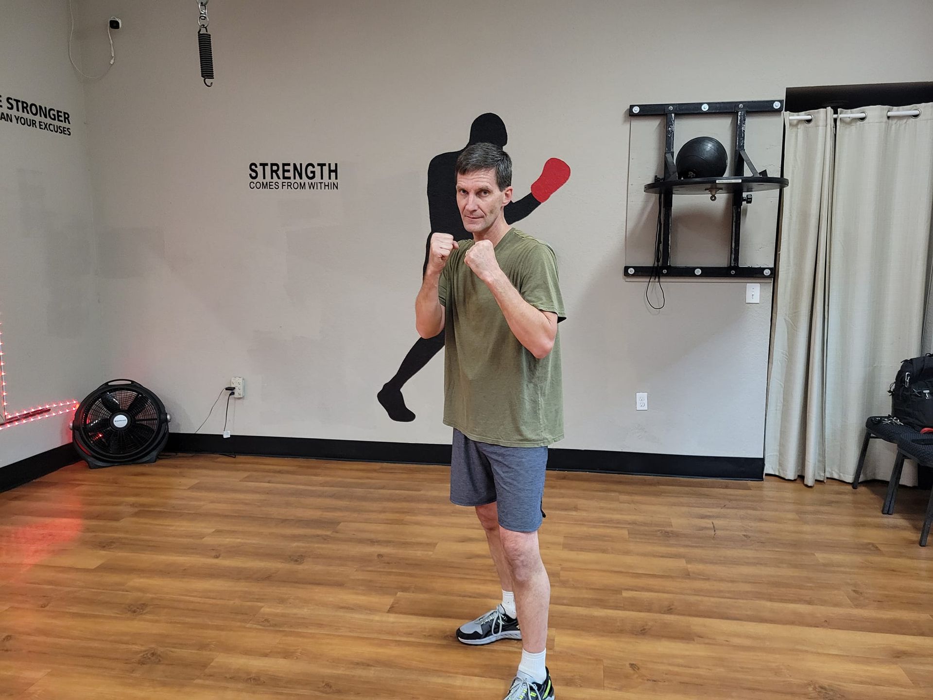 A man is standing in a gym with his fists in the air.