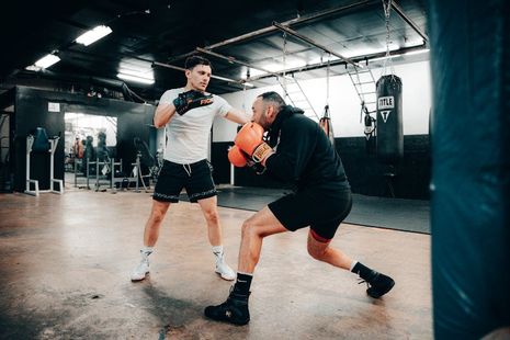 Two men are boxing in a gym.