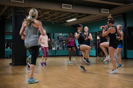 A group of women are dancing in a gym.