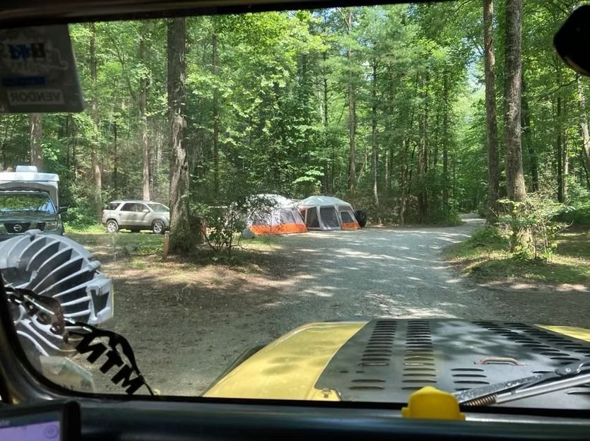 A view of a camping area from the inside of a car.
