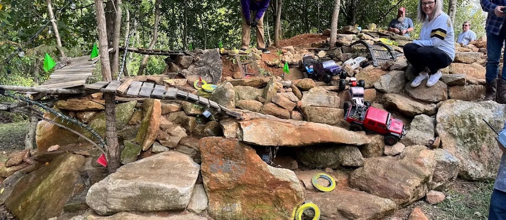 A group of people are sitting on top of a pile of rocks.