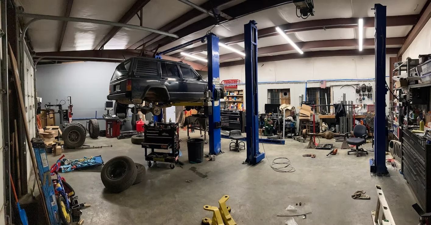 A car is sitting on a lift in a garage.