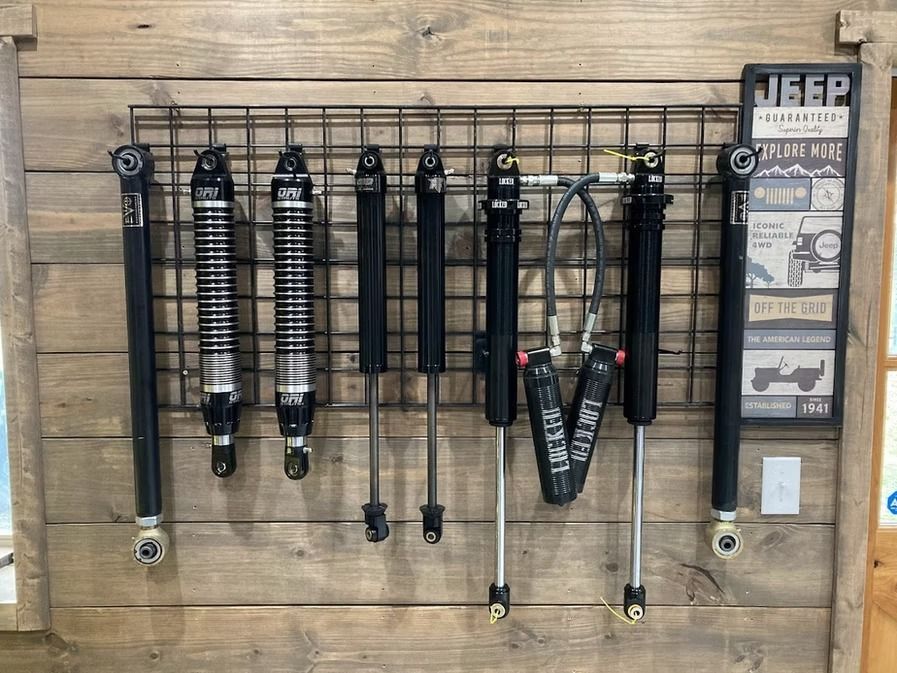 A bunch of different types of shocks are hanging on a wall.