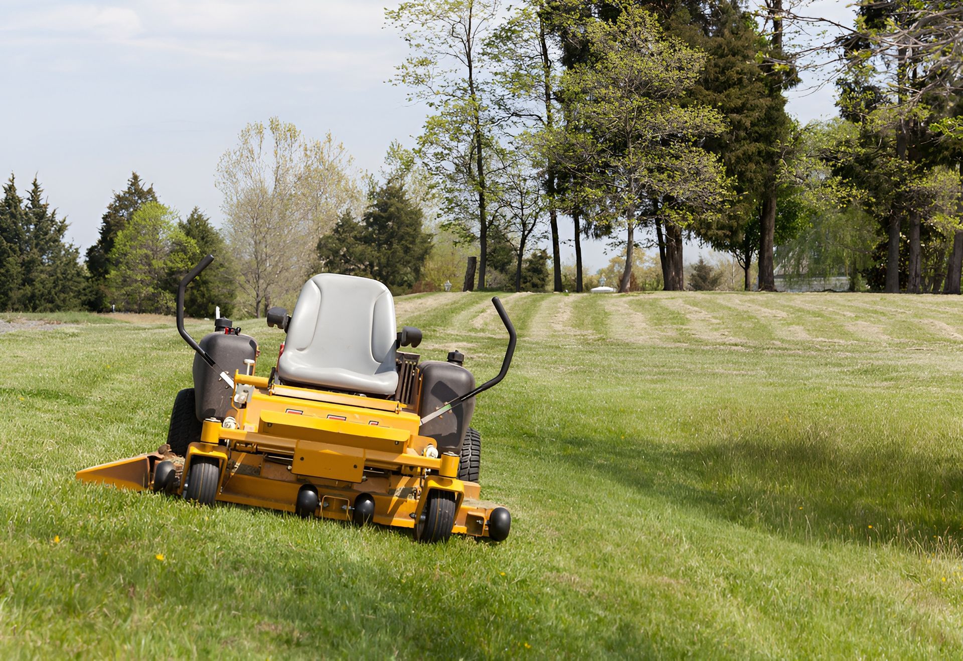 Yellow Zero-turn Lawnmower on a Grassy Hill, Cutting Grass — Garden City Slashing in Highfields, QLD