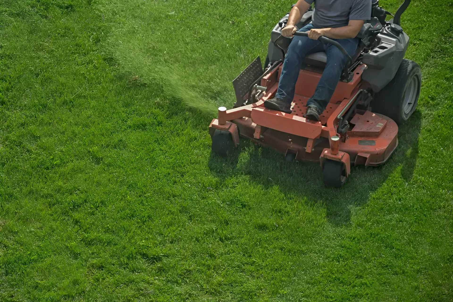 Person Mowing Grass With a Red Zero-turn Lawnmower on a Sunny Day — Garden City Slashing in Highfields, QLD