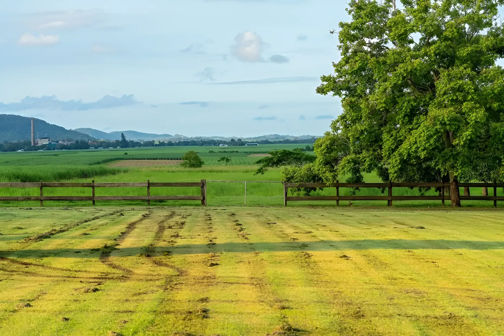 Lush Green Field Bordered by a Wooden Fence — Garden City Slashing in Highfields, QLD