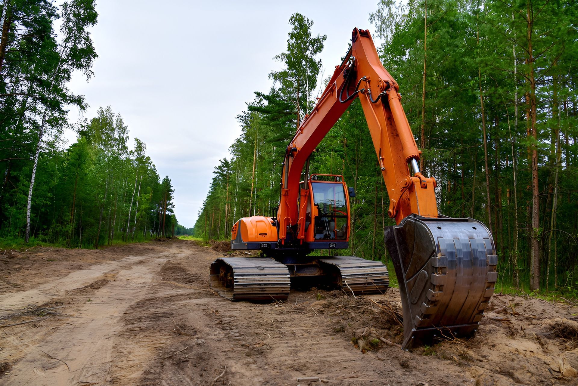 Orange Excavator on a Muddy Road in a Forest, Trees Line the Sides — Garden City Slashing in Highfields, QLD