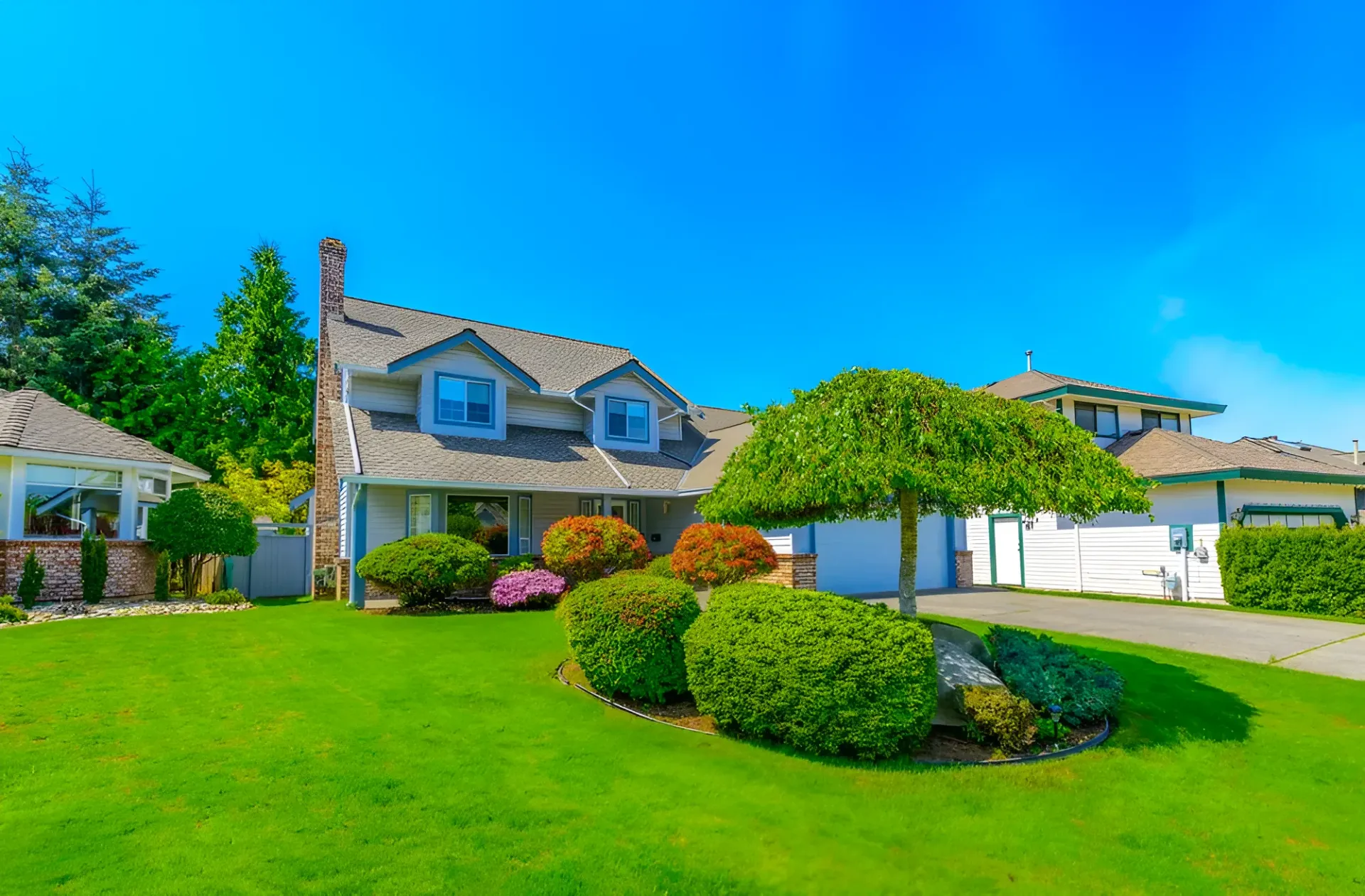 House With a Lush Green Lawn, Landscaped Bushes — Garden City Slashing in Highfields, QLD