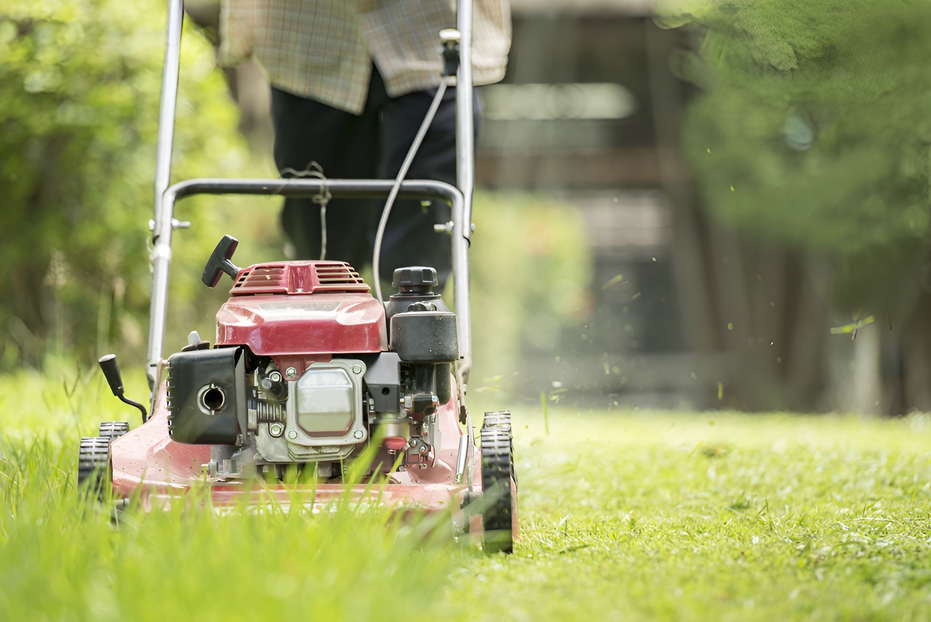 Person Mowing a Grassy Lawn With a Red Lawnmower — Garden City Slashing in Highfields, QLD