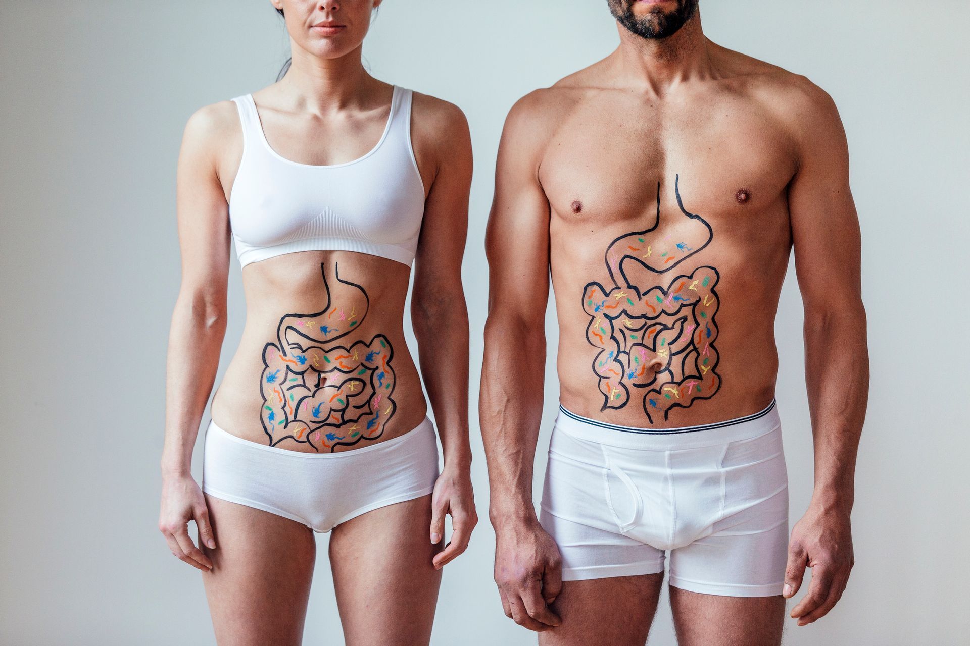 Woman and man with internal organs drawn on their bodies, standing side-by-side.