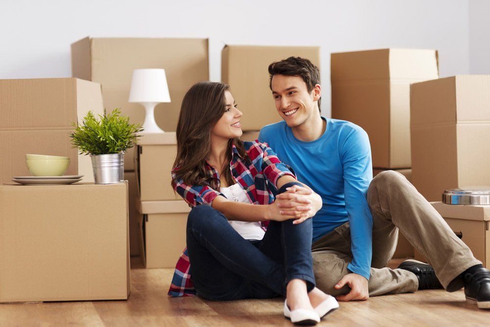 Couple Seating Beside the Boxes — Professional Removalists in Cowra, NSW