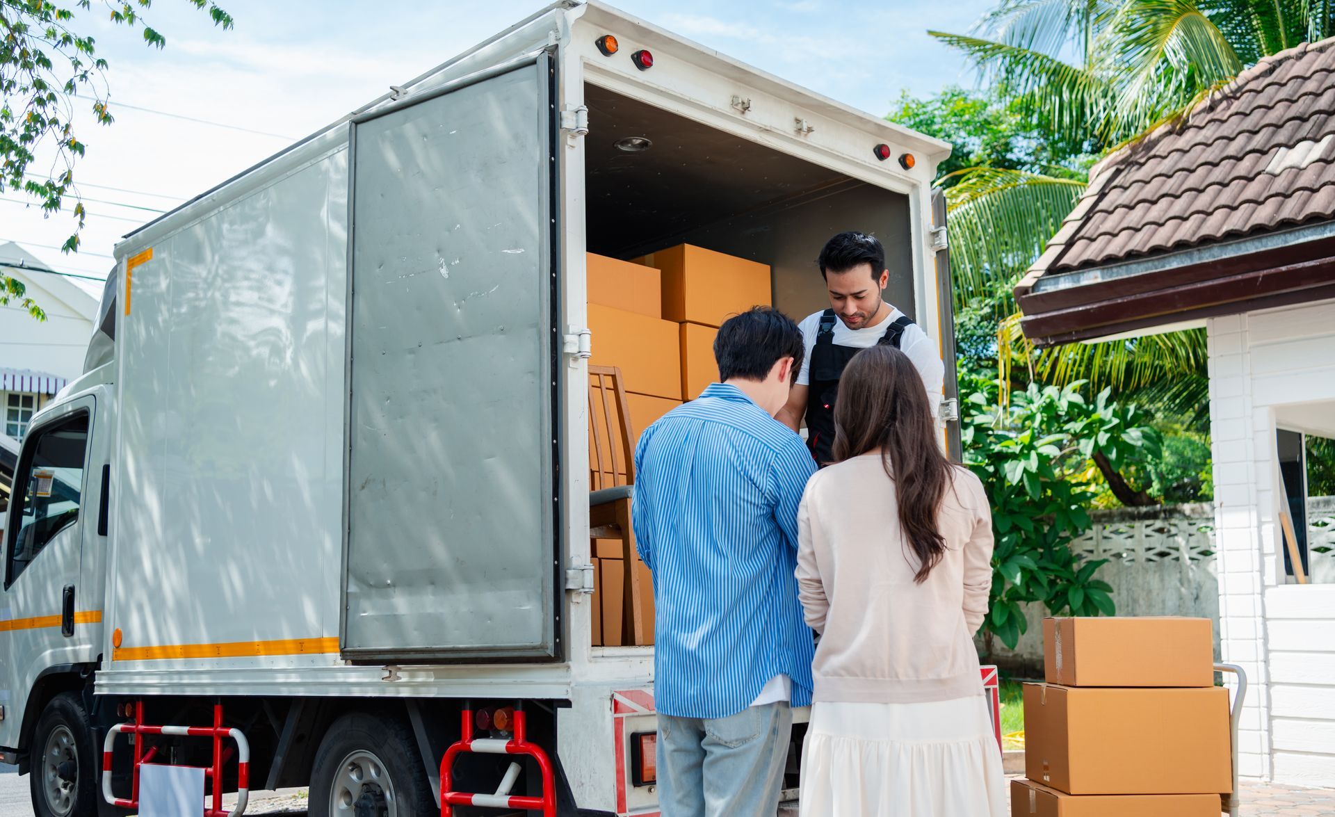 A group of people are standing in front of a moving truck.