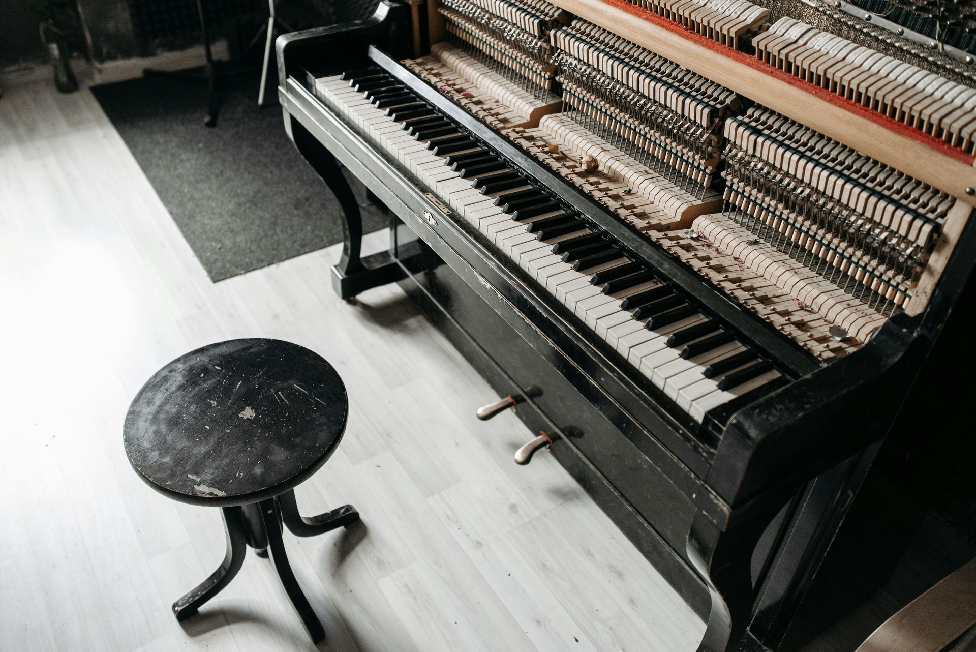 A piano with a stool next to it in a room.