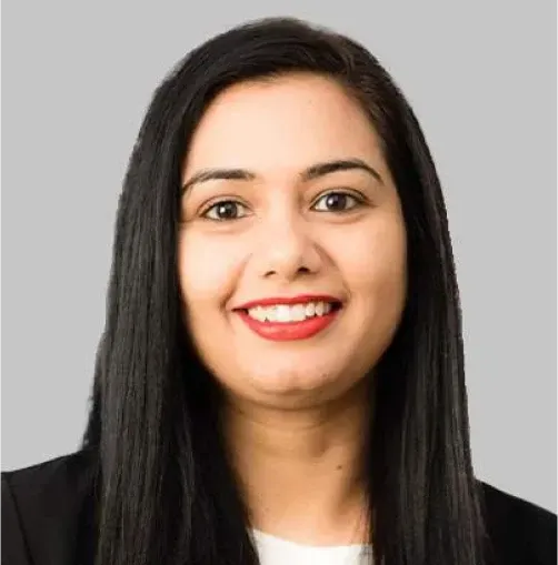 Portrait of a smiling woman with straight black hair, wearing a black blazer against a gray background