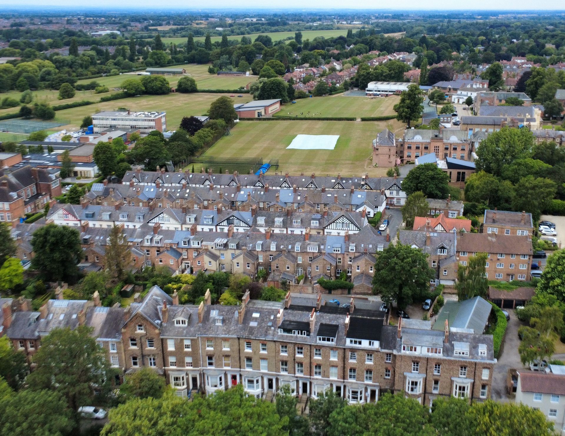 Aerial view of residential neighborhood and sports field on a sunny day.