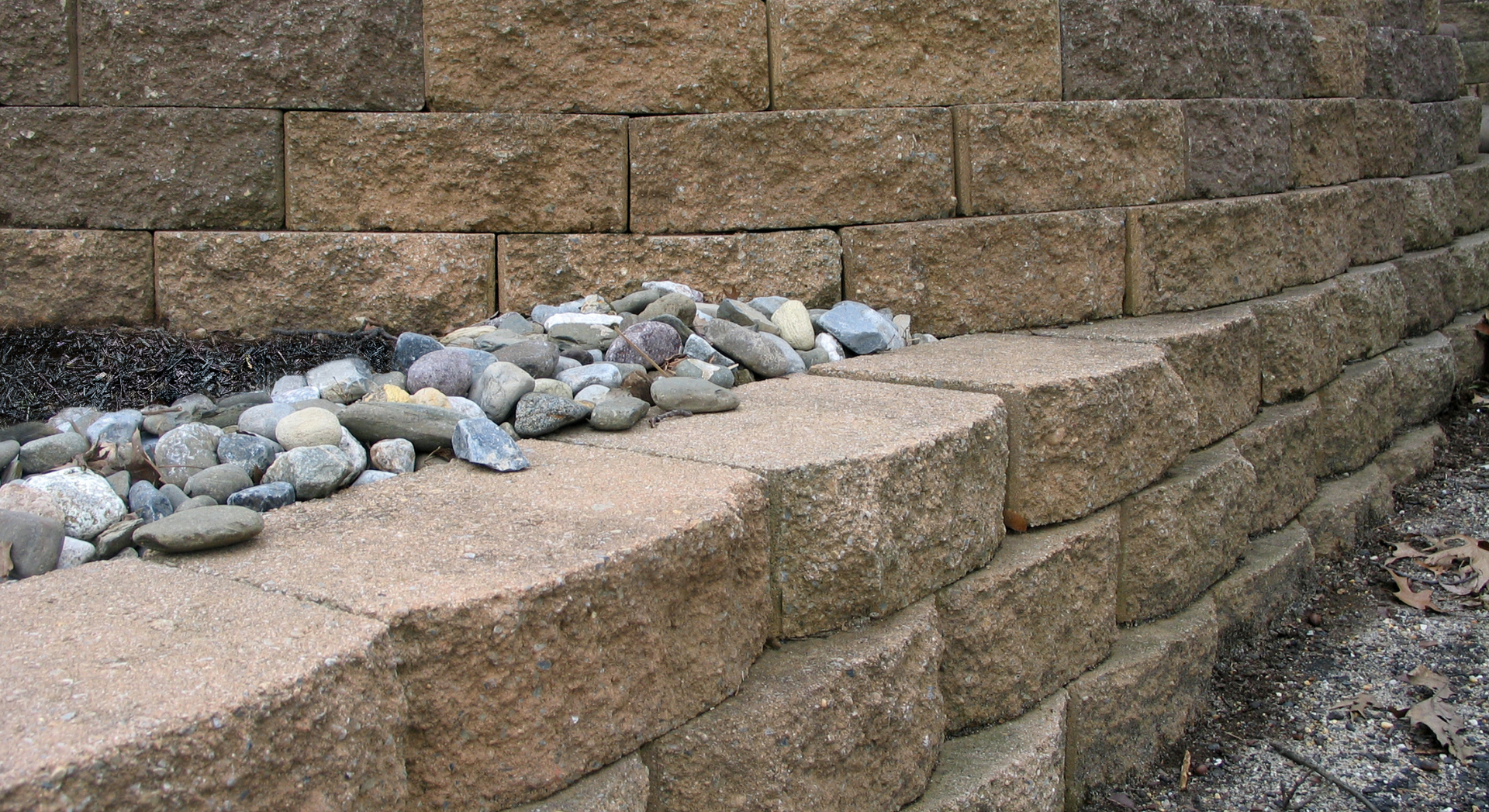A brick wall with rocks on the side of it