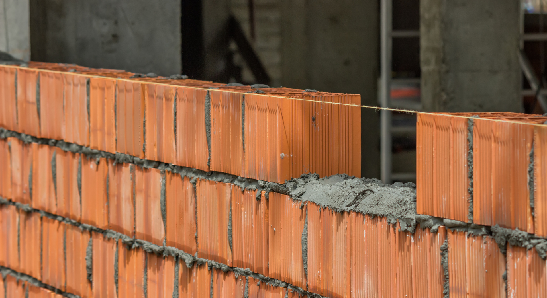 A brick wall is being built on a construction site.