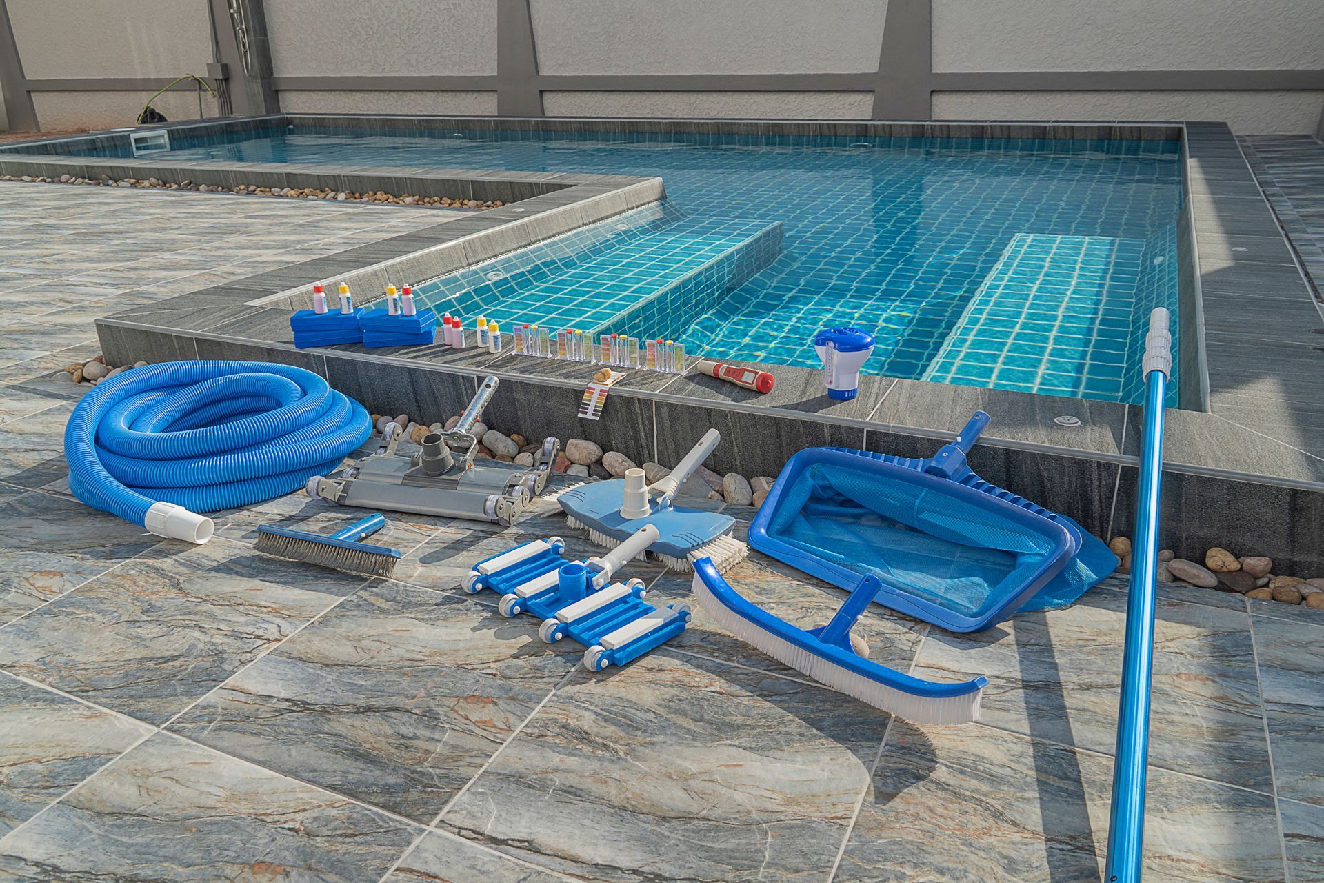 A swimming pool with a lot of cleaning equipment on the side of it.