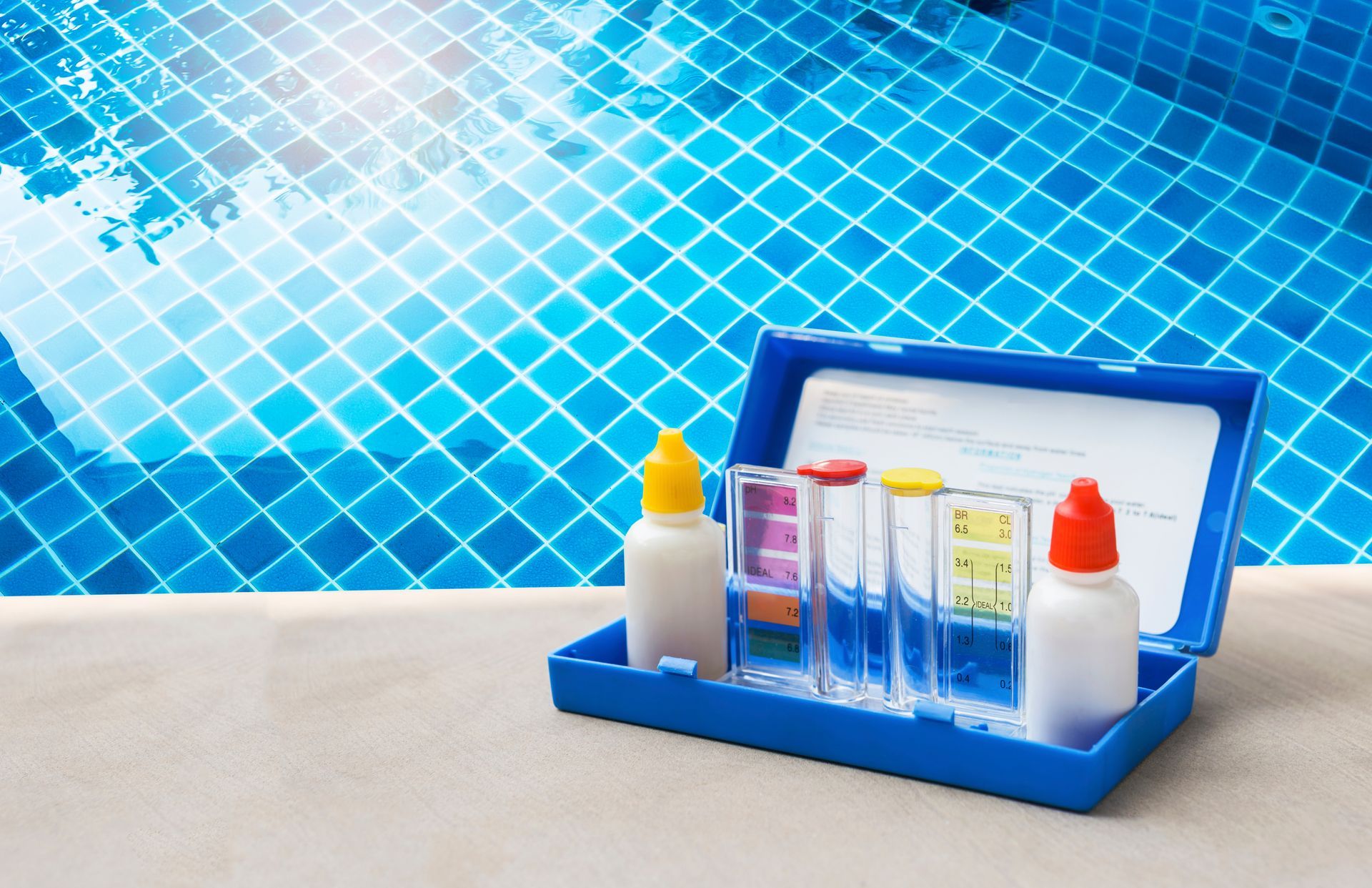 A blue box filled with bottles and test tubes next to a swimming pool.