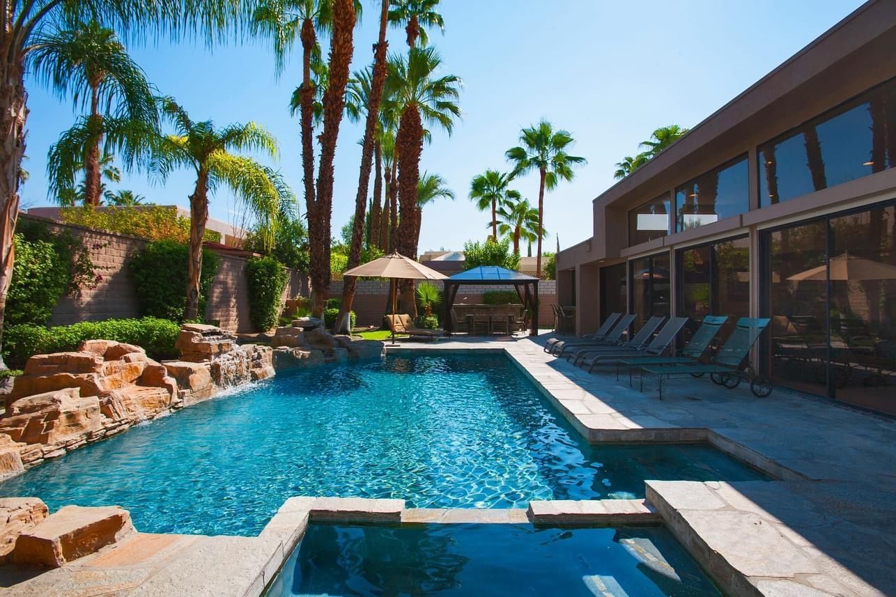 A large swimming pool with palm trees in the background