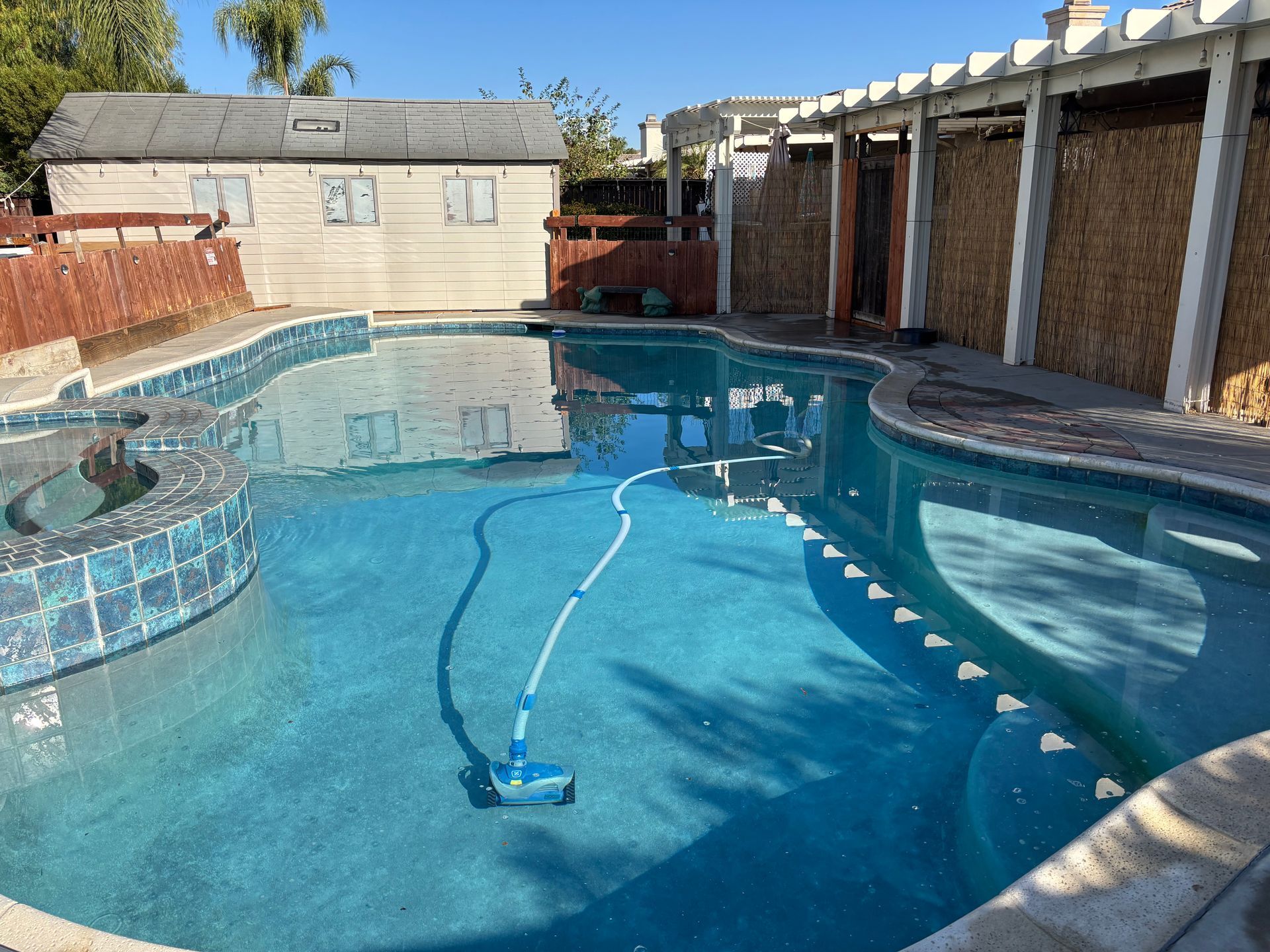 A large swimming pool with a house in the background.