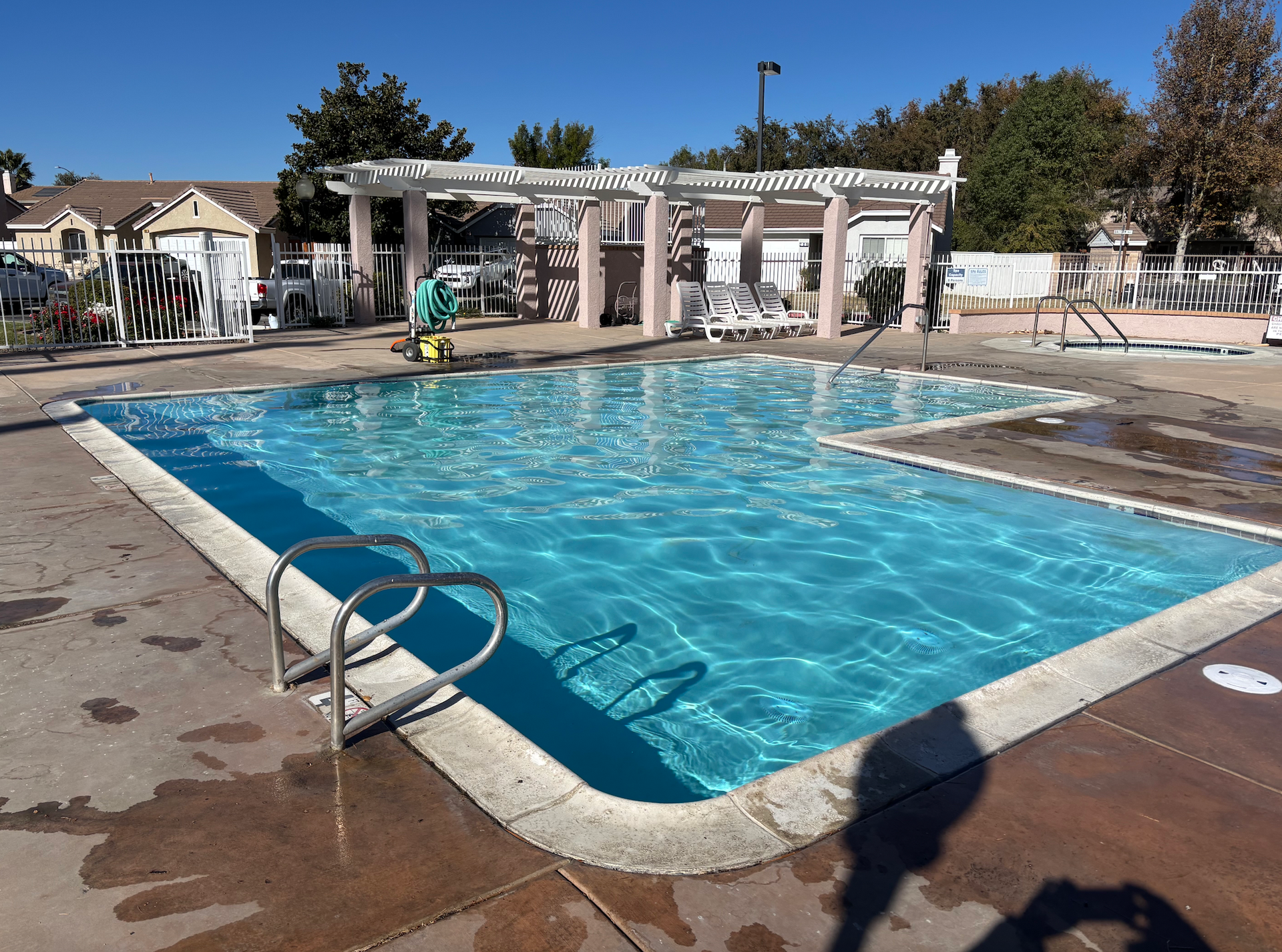 A man is cleaning a swimming pool with a vacuum cleaner.