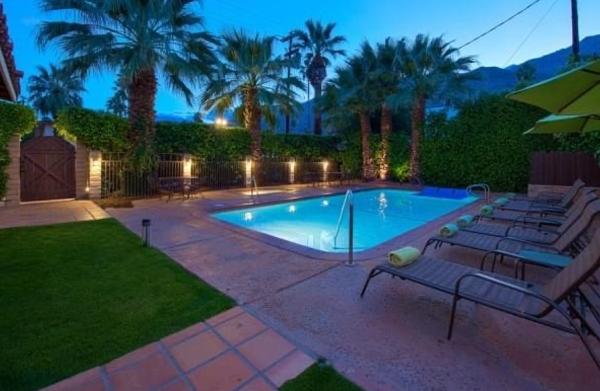 A swimming pool with chairs and umbrellas around it